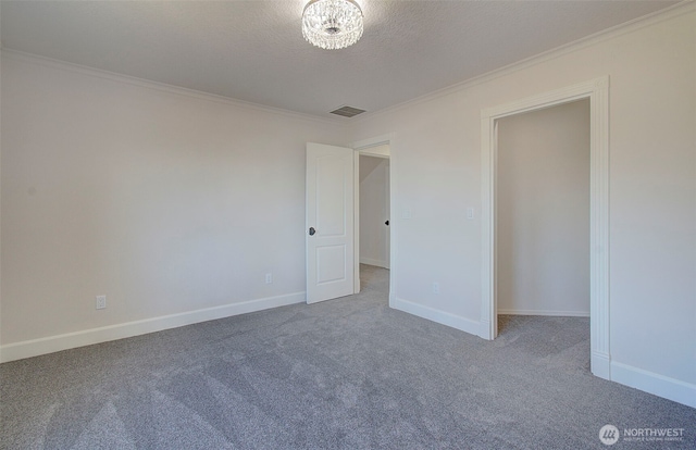 empty room with carpet, crown molding, and baseboards