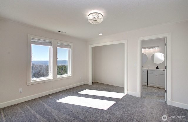 unfurnished bedroom with carpet floors, ensuite bath, visible vents, and baseboards