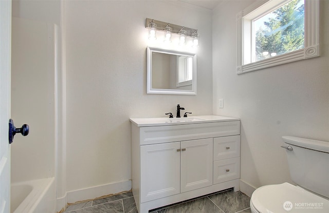 full bathroom with a bath, vanity, toilet, and baseboards