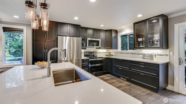 kitchen with tasteful backsplash, light stone counters, stainless steel appliances, and crown molding