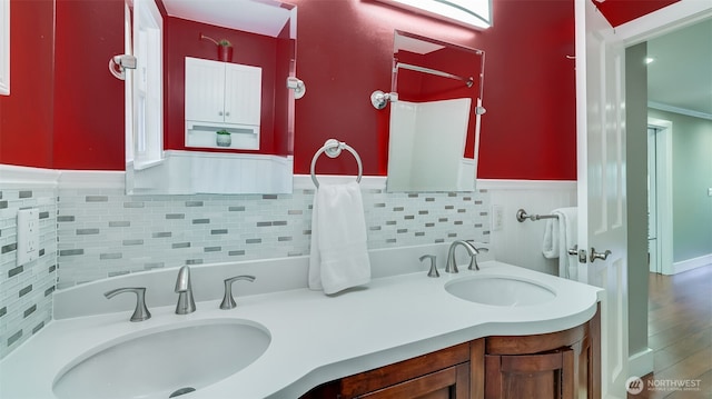 full bathroom featuring a wainscoted wall, a sink, and double vanity