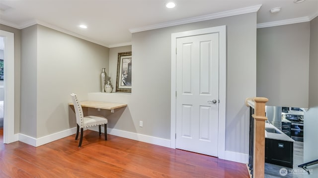 interior space featuring baseboards, ornamental molding, wood finished floors, and recessed lighting