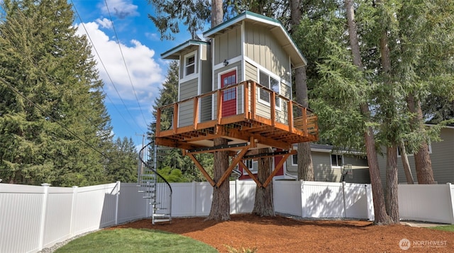 view of front of home featuring stairway, board and batten siding, a fenced backyard, and a wooden deck