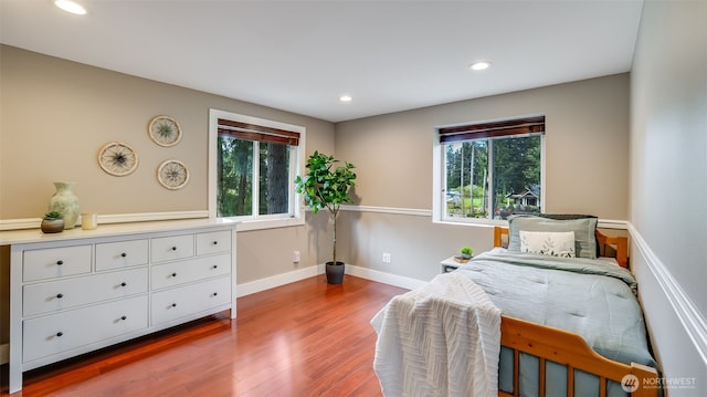 bedroom with baseboards, wood finished floors, and recessed lighting