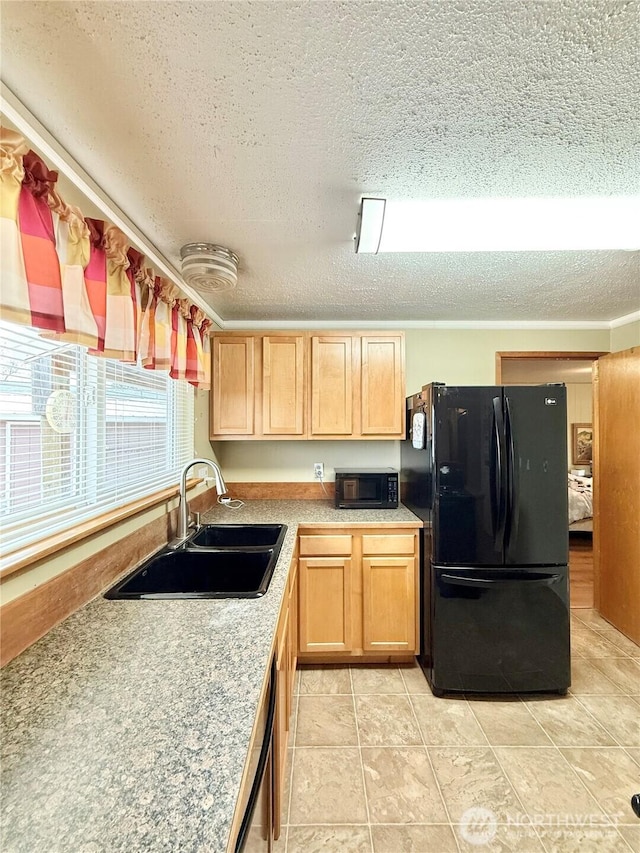 kitchen featuring a textured ceiling, black appliances, light brown cabinetry, and a sink