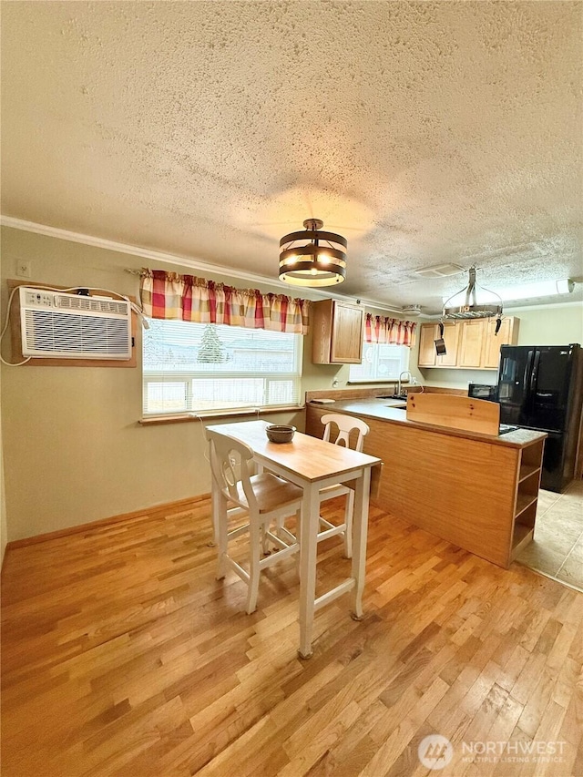 kitchen featuring a peninsula, freestanding refrigerator, light wood-style floors, a textured ceiling, and a wall mounted AC