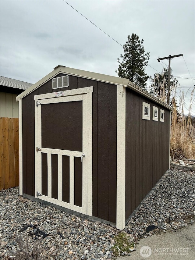 view of shed featuring fence