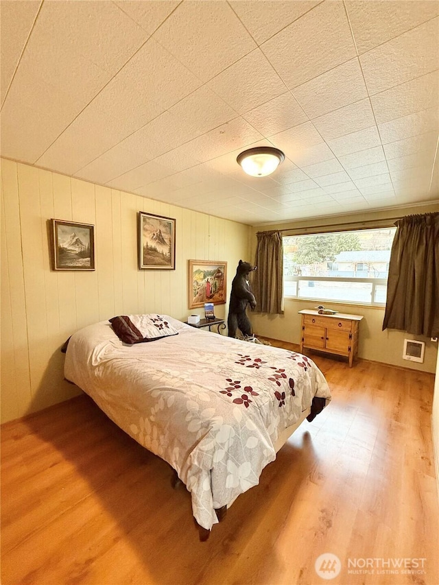 bedroom with visible vents and wood finished floors