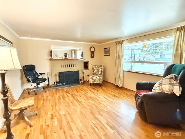 living room featuring a brick fireplace, crown molding, and wood finished floors