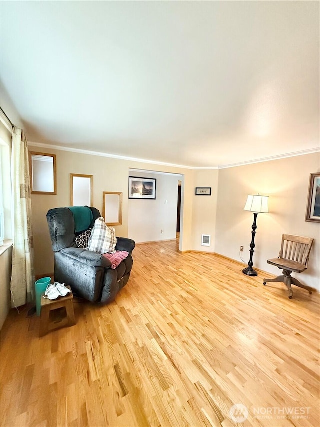 living area featuring visible vents, ornamental molding, and wood finished floors