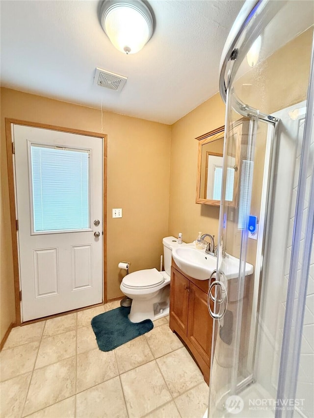 bathroom with visible vents, toilet, a stall shower, tile patterned floors, and vanity