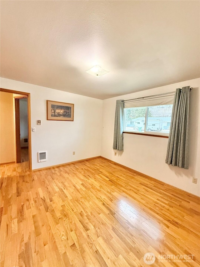 unfurnished room with visible vents, baseboards, and light wood-style flooring