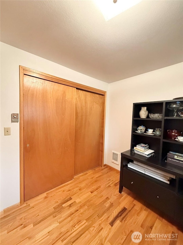 interior space featuring wood finished floors, visible vents, and a textured ceiling