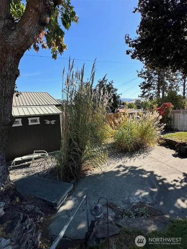 view of yard featuring an outbuilding and fence