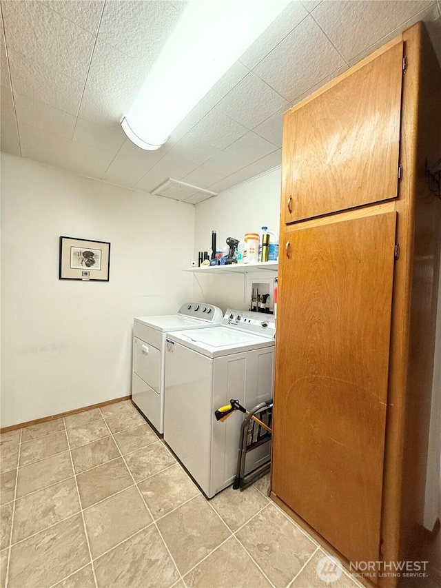 laundry area featuring baseboards, washing machine and dryer, light tile patterned floors, laundry area, and a textured ceiling