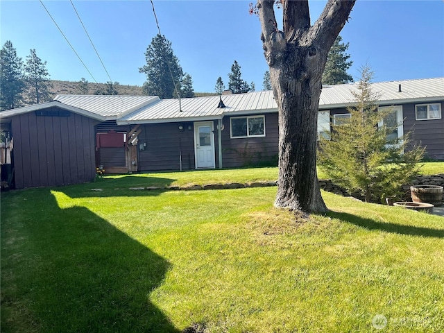 back of house with a yard and metal roof