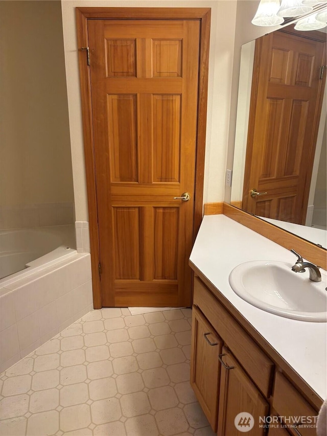 full bath with vanity and tiled bath