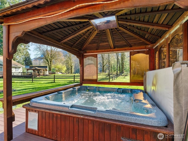 exterior space featuring a hot tub, a lawn, and a gazebo