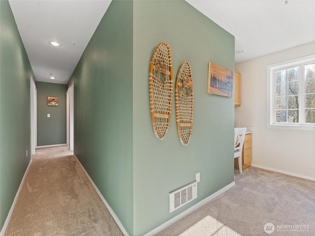 hallway featuring light carpet, recessed lighting, visible vents, and baseboards