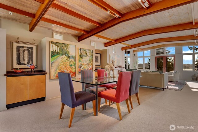 dining area with light carpet, lofted ceiling with beams, and wooden ceiling