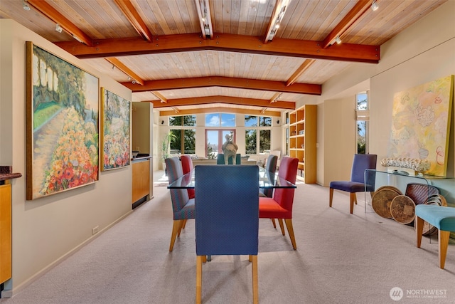 dining area featuring rail lighting, wooden ceiling, light colored carpet, and lofted ceiling with beams