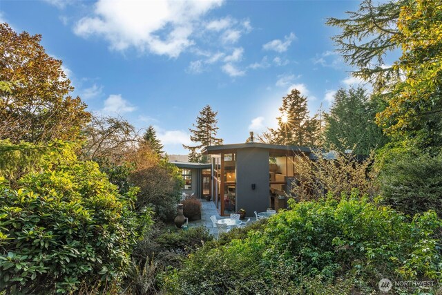 rear view of house featuring stucco siding