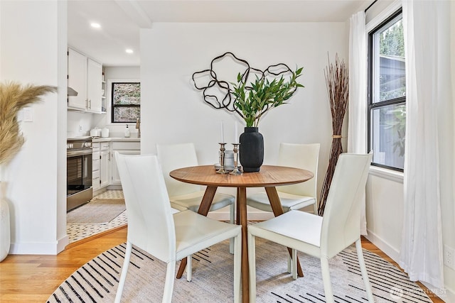 dining space featuring light wood finished floors, recessed lighting, and baseboards