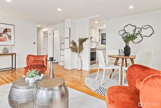 living area with recessed lighting, light wood-type flooring, and baseboards