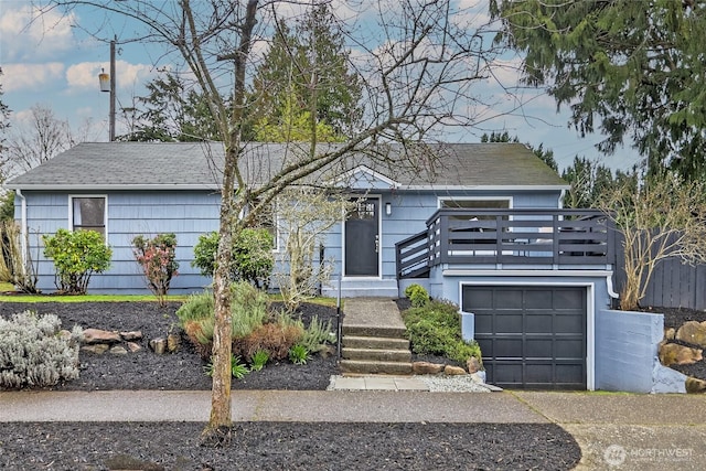 view of front facade with a garage and roof with shingles