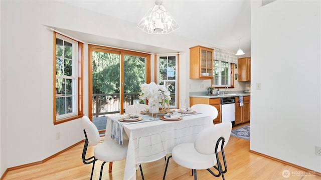 dining room featuring a notable chandelier, baseboards, and light wood-style floors