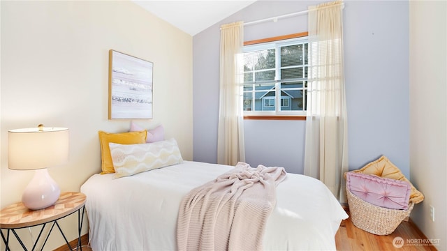 bedroom featuring wood finished floors and vaulted ceiling