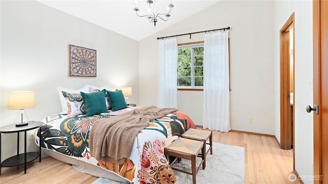 bedroom with an inviting chandelier, lofted ceiling, and light wood finished floors