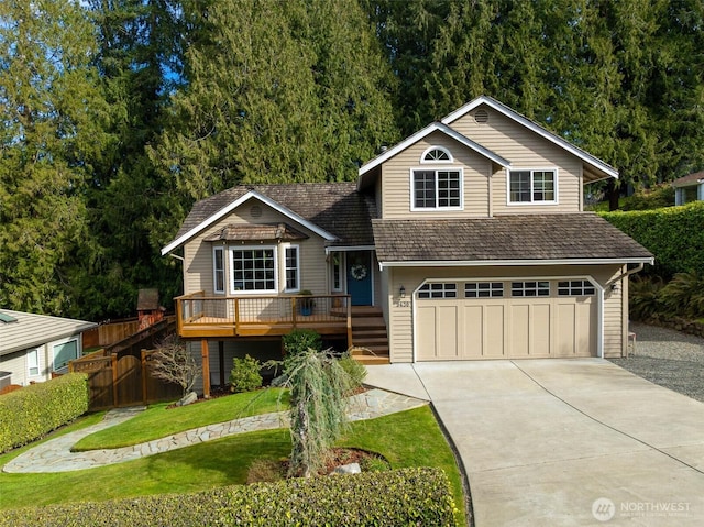 view of front of home featuring fence, concrete driveway, a front yard, a garage, and a deck