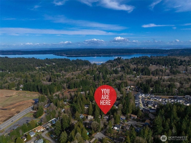 birds eye view of property featuring a wooded view and a water view