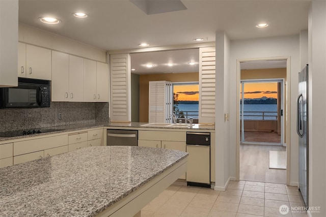 kitchen with light tile patterned floors, tasteful backsplash, recessed lighting, a sink, and black appliances