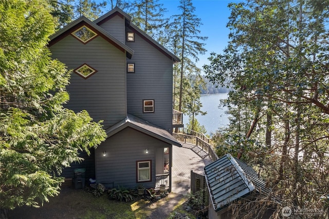 view of side of home with a water view and stairs