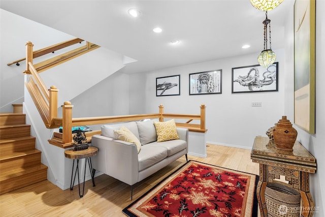 living area with baseboards, wood finished floors, and recessed lighting