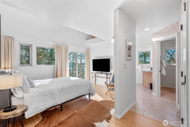 bedroom with multiple windows, baseboards, and light tile patterned floors