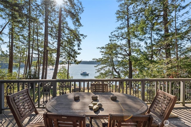 wooden terrace with outdoor dining space and a water view