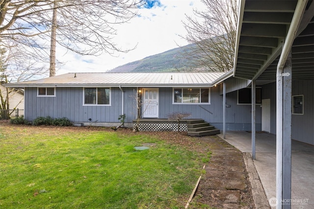 view of front facade featuring metal roof and a front yard