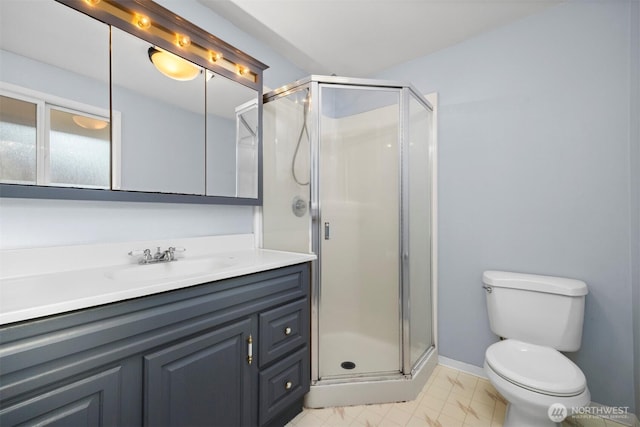 bathroom with baseboards, toilet, a stall shower, and vanity