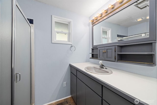 full bathroom with an enclosed shower, visible vents, and vanity