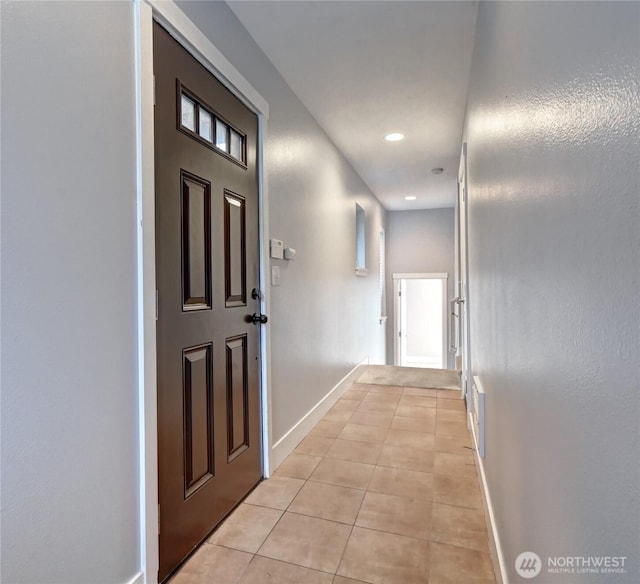 corridor featuring light tile patterned floors, baseboards, and recessed lighting