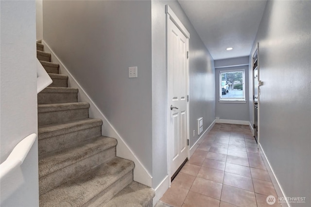 staircase featuring tile patterned flooring, visible vents, and baseboards