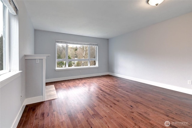 spare room with baseboards and wood-type flooring