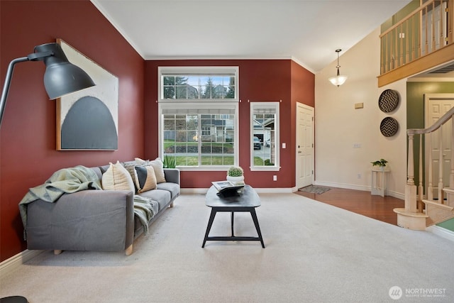 carpeted living room with visible vents, baseboards, vaulted ceiling, stairway, and crown molding