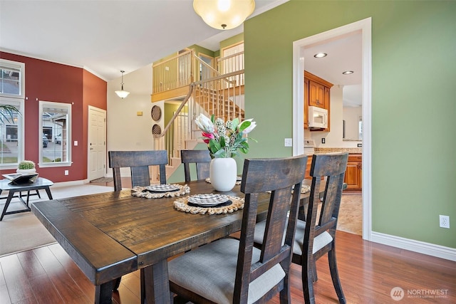 dining area featuring stairway, baseboards, and wood finished floors