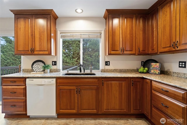 kitchen featuring plenty of natural light, white dishwasher, a sink, and brown cabinets