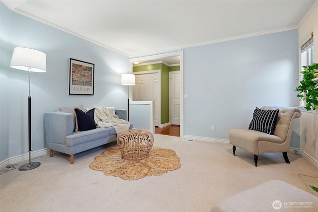 sitting room with carpet floors, crown molding, and baseboards