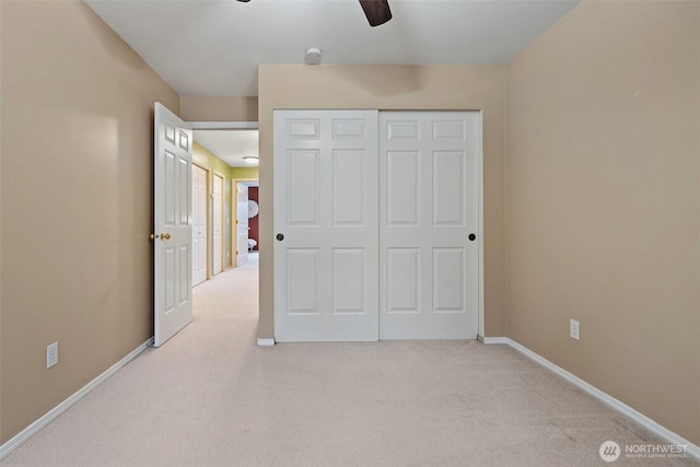 carpeted bedroom with ceiling fan, baseboards, and a closet